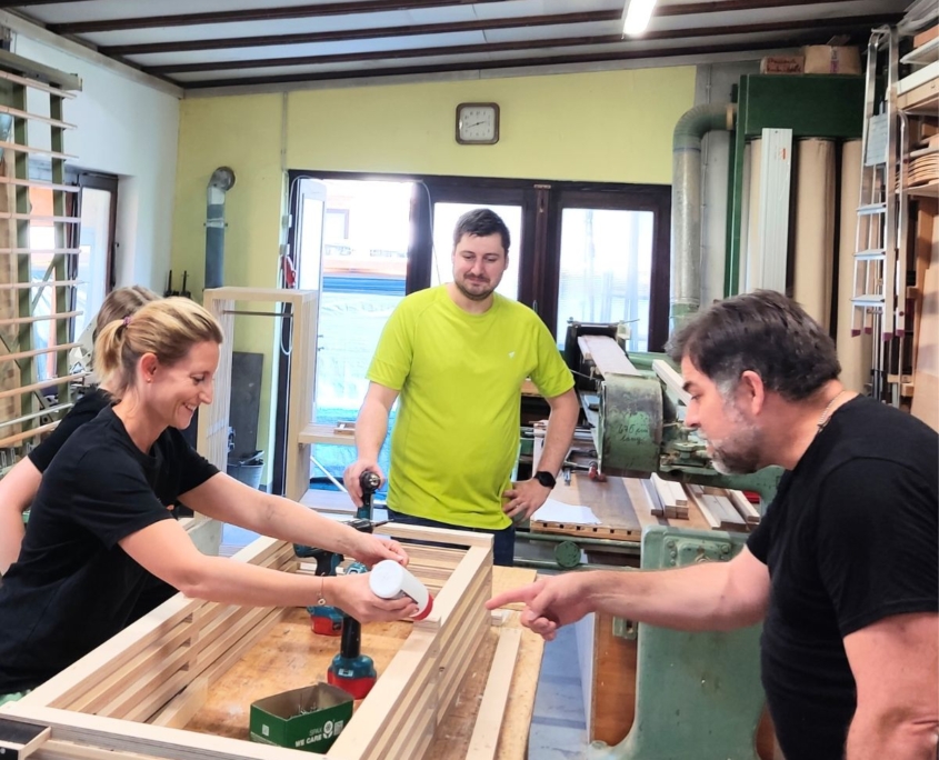 Ein Team baut zusammen ein Holzregal fürs Büro in einem Teambuilding-Schreiner-Workshop für Unternehmen im Rhein-Neckar Kreis