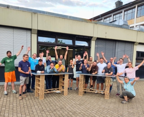 Teambuilding-Workshop Team mit selbstgebauten Meetingtischen. Das Ergebnis.