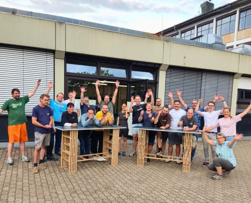 Teambuilding-Workshop Team mit selbstgebauten Meetingtischen. Das Ergebnis.