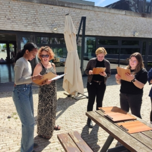 Ein Team reflektiert seine Stärken im Team. Draußen an einem sonnigen Tag mit Klemmbrettern in der Hand. Entwicklungs-Workshop von Melanie Wabro